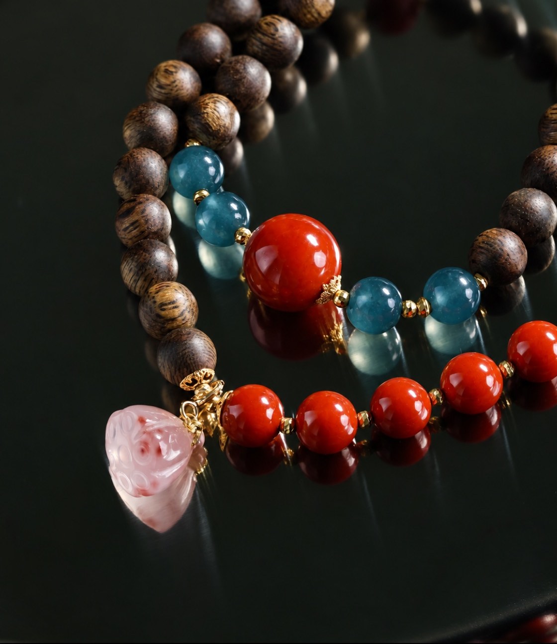 Close view of No. 03: a full vermilion bead among blue-teal and deep brown beads, a run of small red beads and a pale pink drop