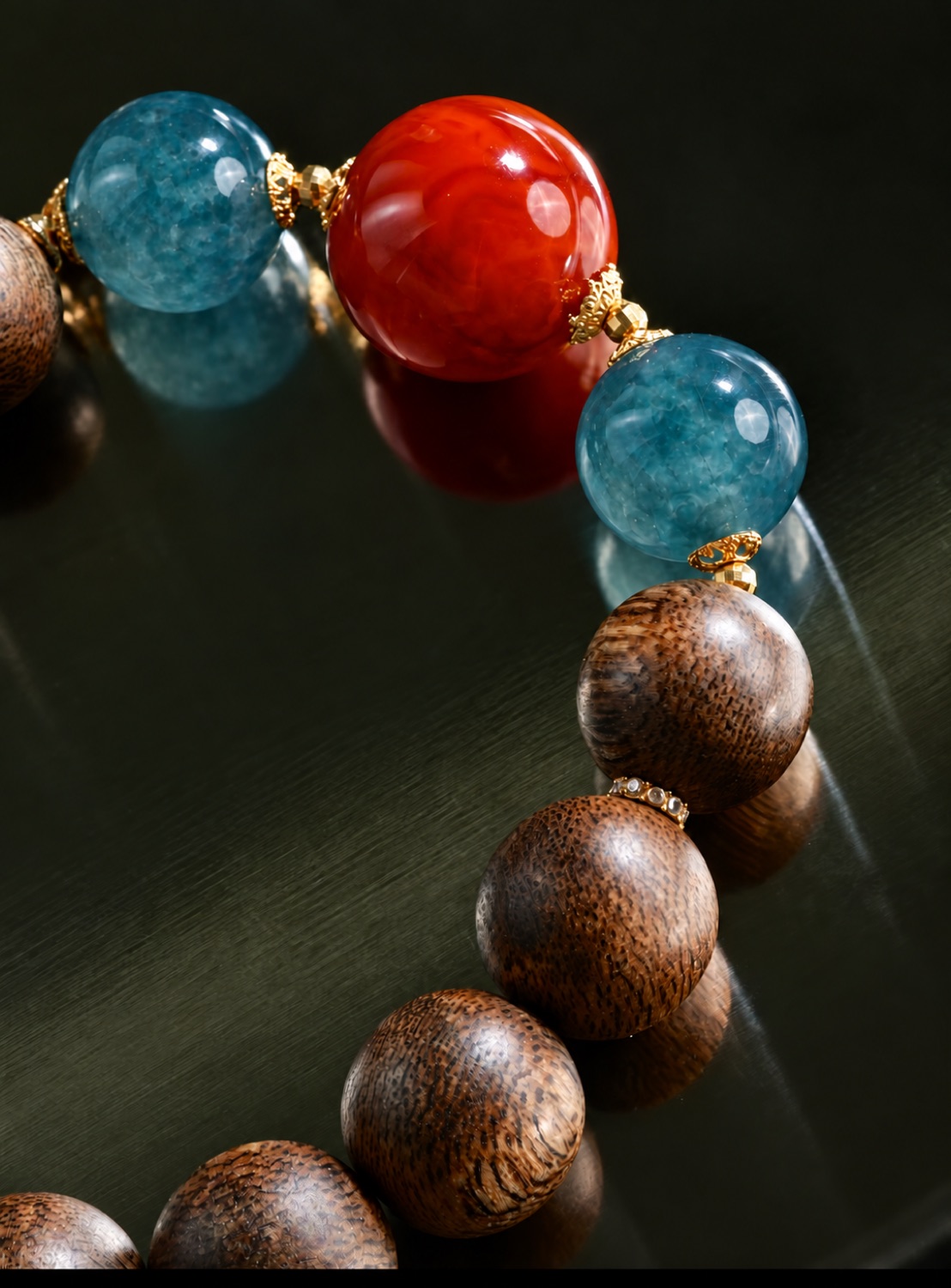 Close view of wood beads beside blue-teal and vermilion stones